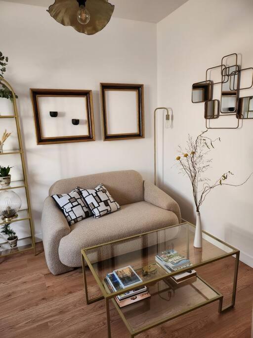 ein Wohnzimmer mit einem Sofa und einem Glastisch in der Unterkunft La maisonnette des hautes granges in Blois