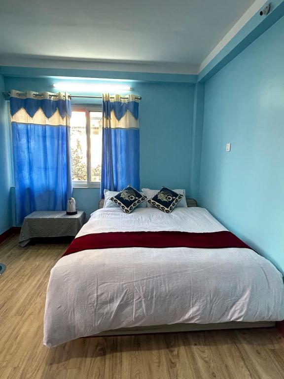a bedroom with a large bed with blue walls at Sagarmatha View Homes in Kathmandu