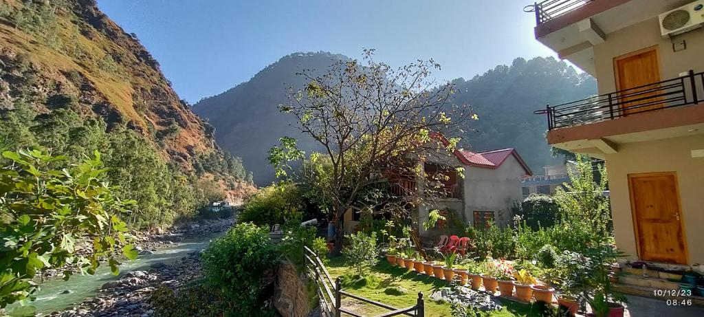 Banjār的住宿－Tirthan Grand Riverside，享有河流和山脉景色的建筑