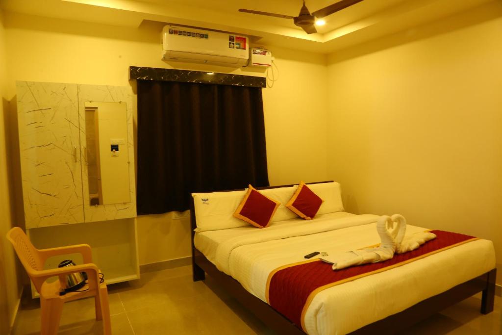 a bedroom with a bed with a fan on the ceiling at Hotel Elite Inn in Srikalahasti
