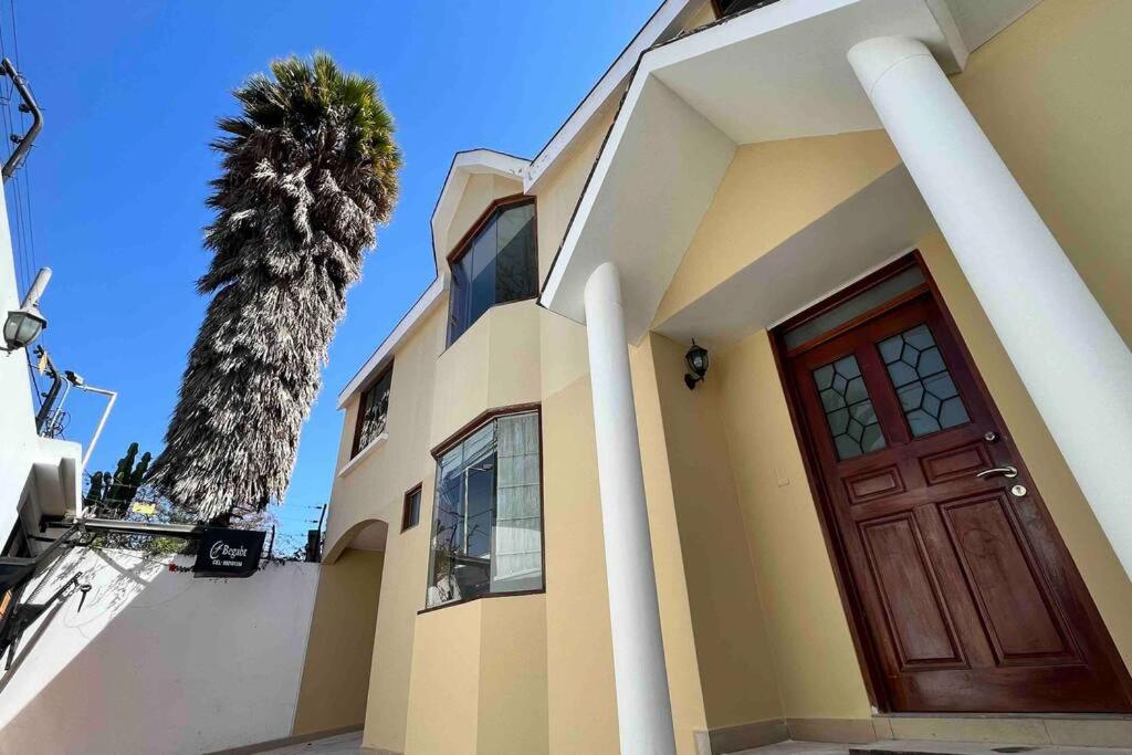 a house with a door and a palm tree at Hermosa Casa completa en Arequipa 