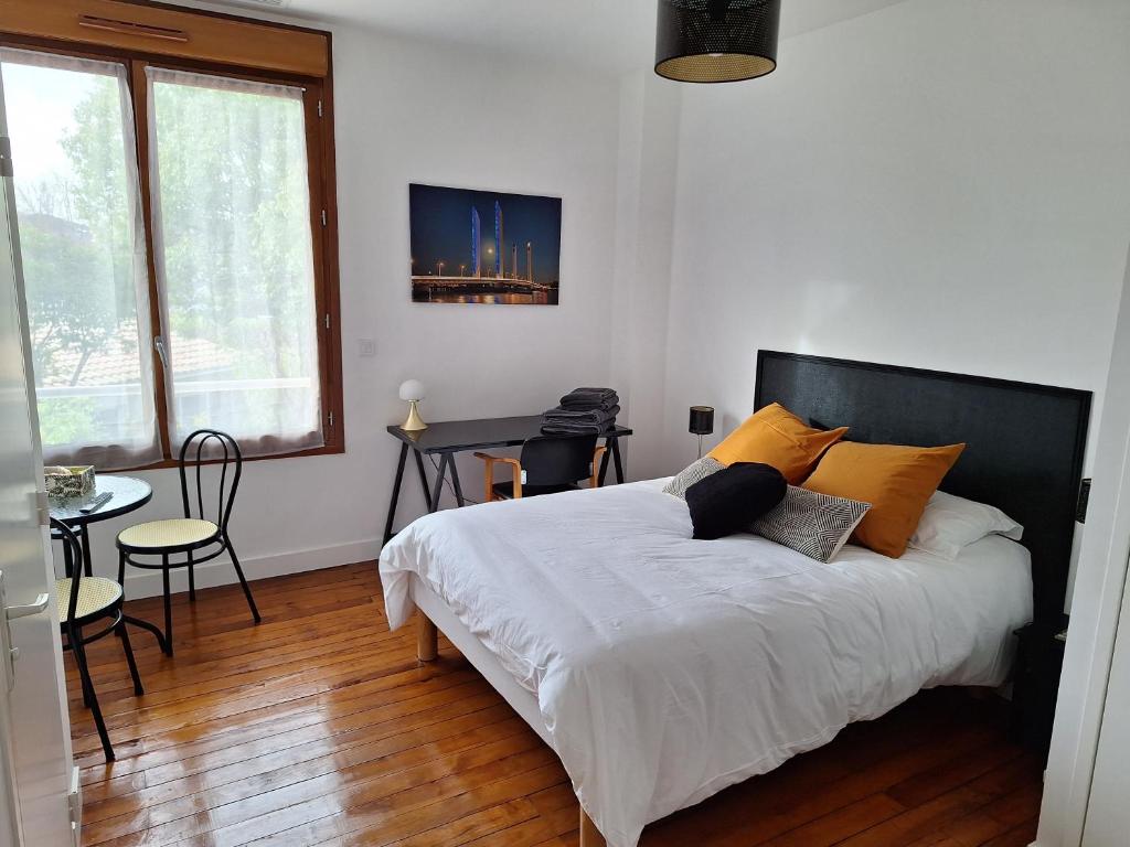 a bedroom with a bed and a table with chairs at La Maison Partagée d'Arlac in Mérignac