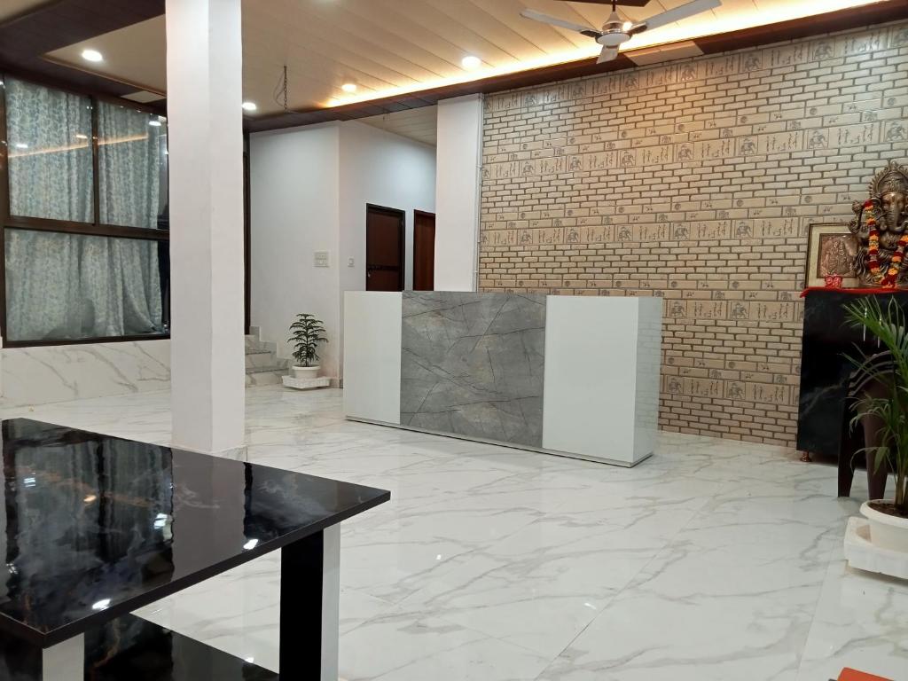 - un hall avec un sol en marbre blanc et un mur en briques dans l'établissement 5 PETALS, à Varanasi