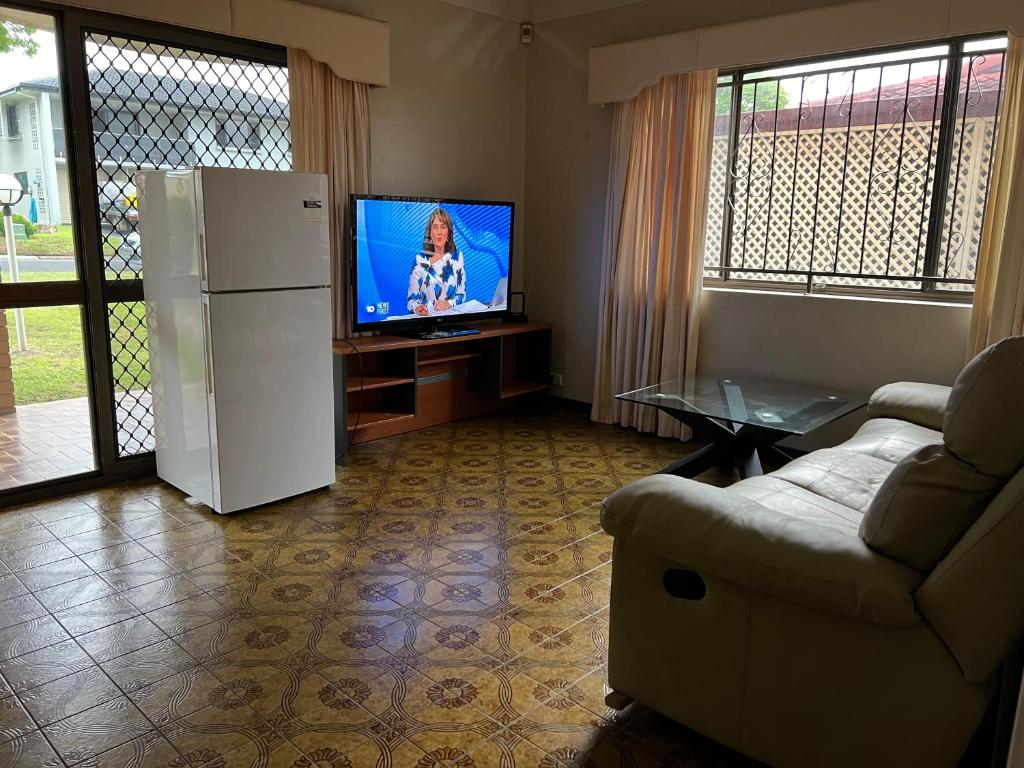 a living room with a refrigerator and a tv at Aspley large room & share bathroom with other guests in Brisbane