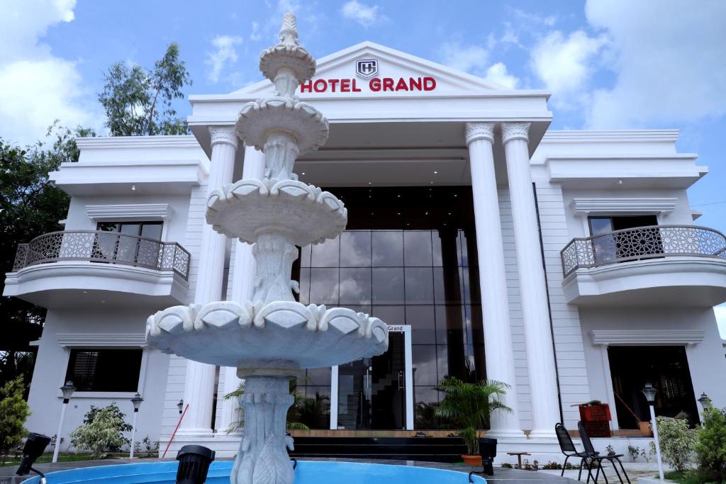 un edificio con una fontana di fronte a un'edicola di Hotel Grand a Khuldābād
