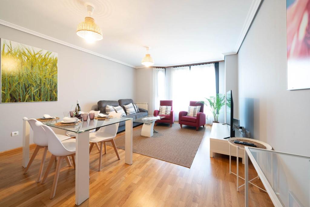 a dining room and living room with a table and chairs at Apartamentos GO - Arroyo San José in Arroyo de la Encomienda