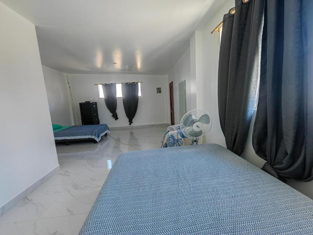 um quarto com uma cama azul num quarto em Cuarto en galápagos em Puerto Baquerizo Moreno