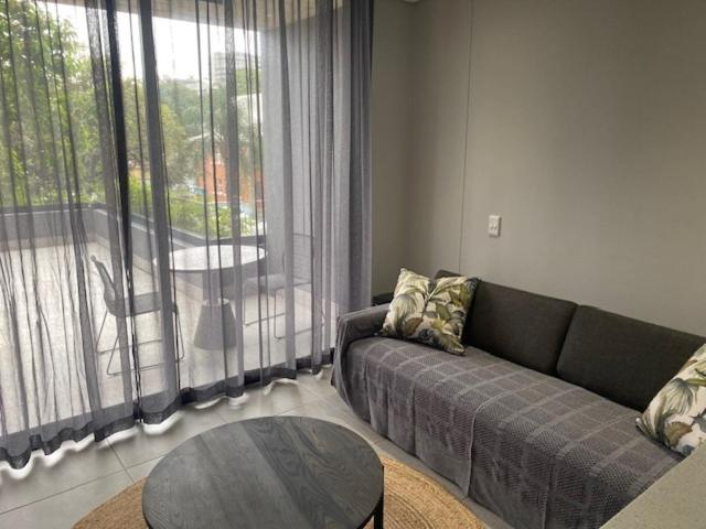 Trendy Apartment في ديربان: غرفة معيشة مع أريكة وطاولة