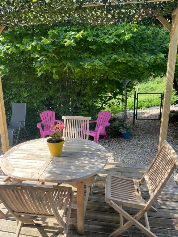 a wooden table and chairs on a patio at GITE CHALET BOIS in Bessuéjouls