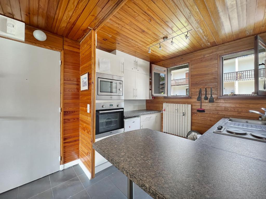 - une cuisine avec des murs en bois et un grand comptoir dans l'établissement 3 Pièces 6/8 Pers centre Carroz (AA111), aux Carroz d'Arâches