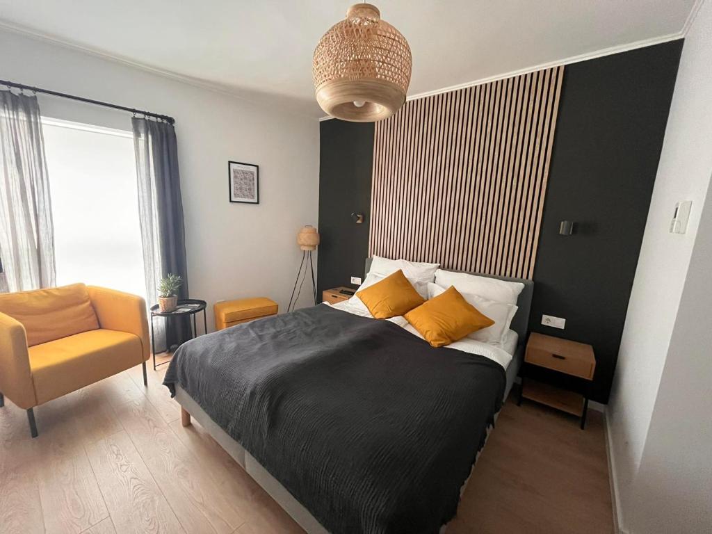 1 dormitorio con 1 cama y 1 silla en Central Studio en Pécs