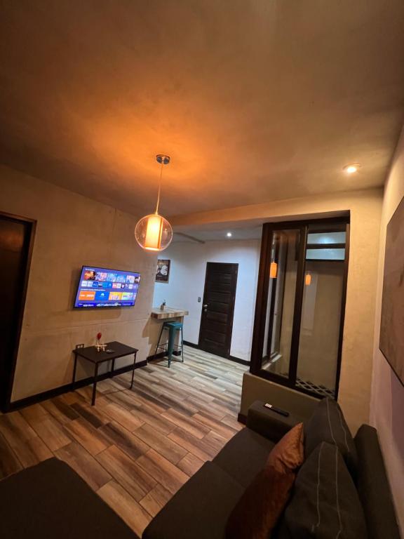 Apartamento G4 في غواتيمالا: غرفة معيشة مع أريكة وتلفزيون بشاشة مسطحة