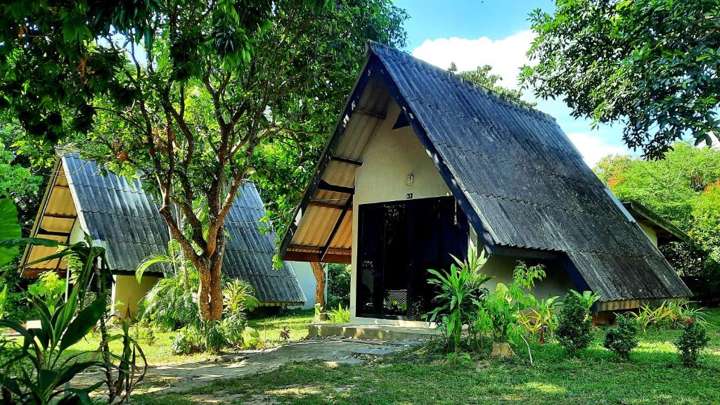 a small house with a black roof with a door at Cashewnut Tree Resort in Ko Lanta