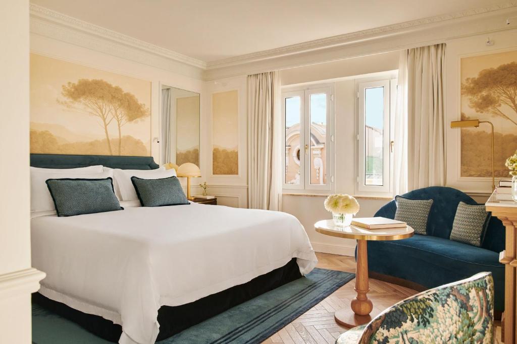 a bedroom with a white bed and a blue couch at The Westin Palace, Madrid in Madrid