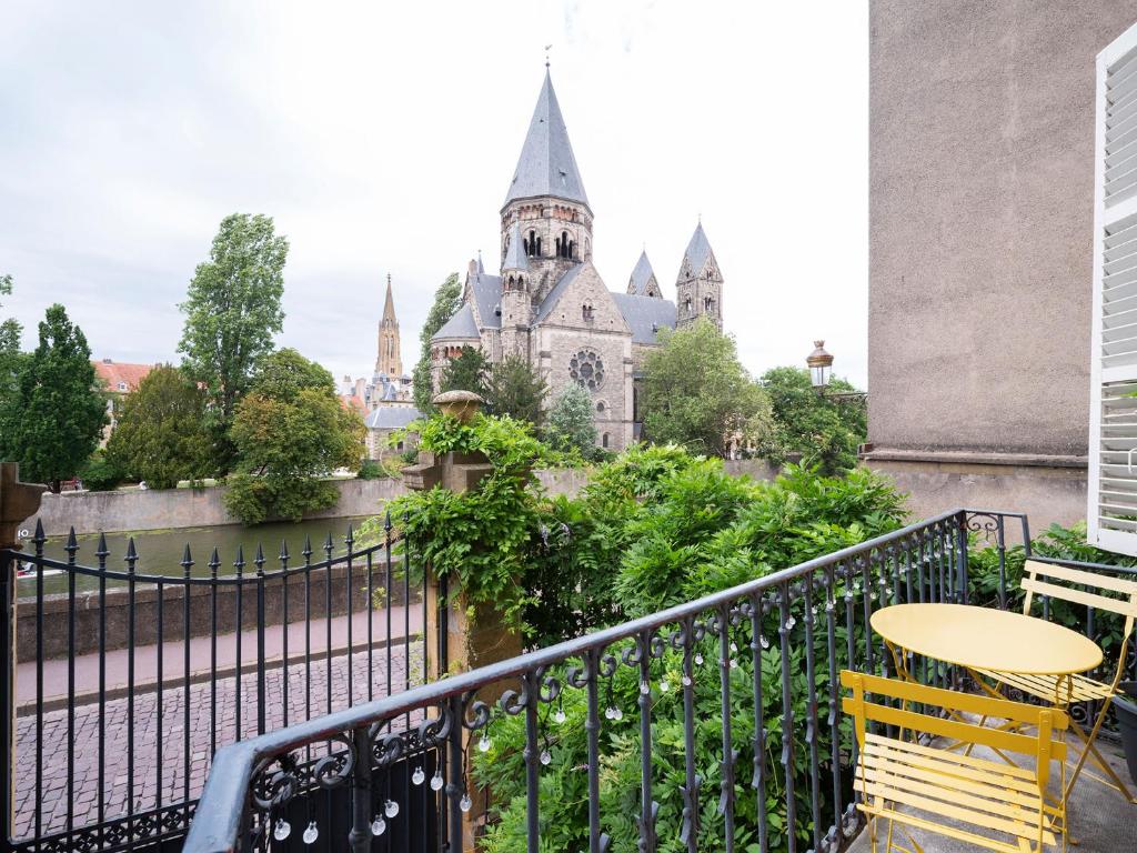 - un balcon avec une table et des chaises dans l'établissement Une Romance au bord de l’eau (en hyper-centre), à Metz