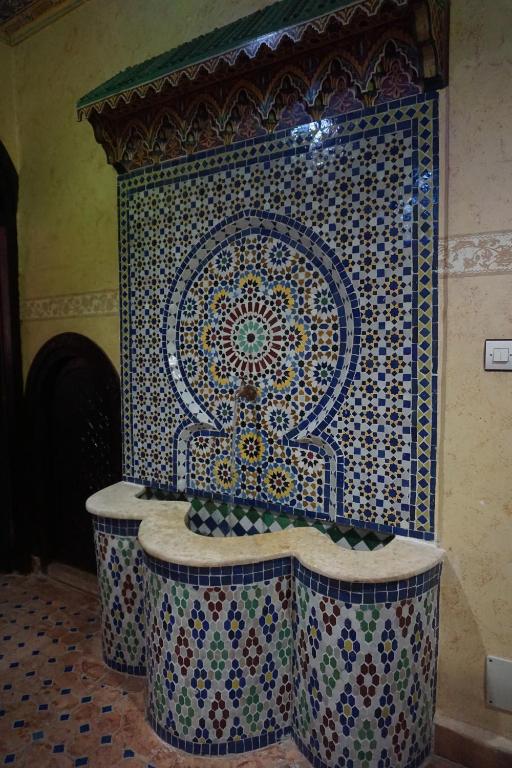 baño con mosaico en la pared y bañera en Riad Andalousse, en Meknès