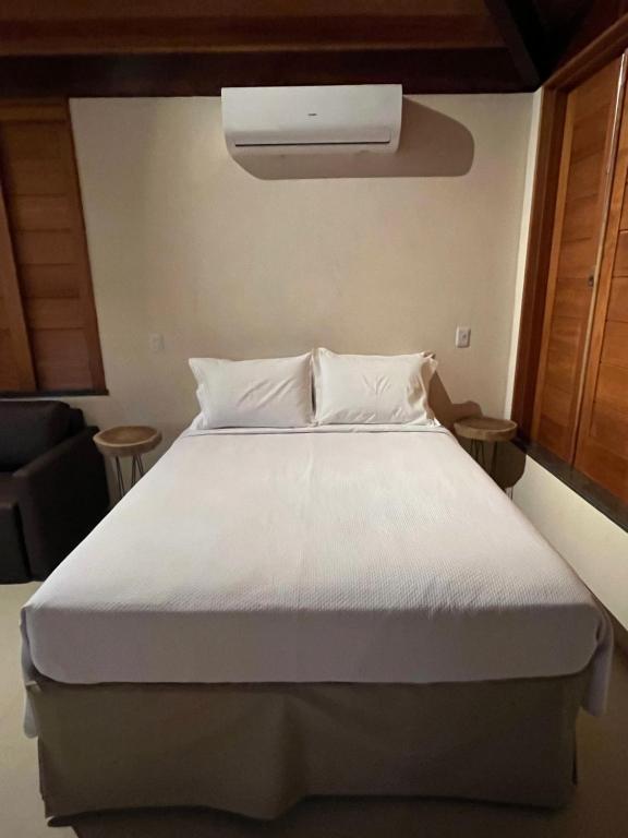 1 dormitorio con 1 cama grande y edredón blanco en Quinta do Sossego, en Mata de Sao Joao
