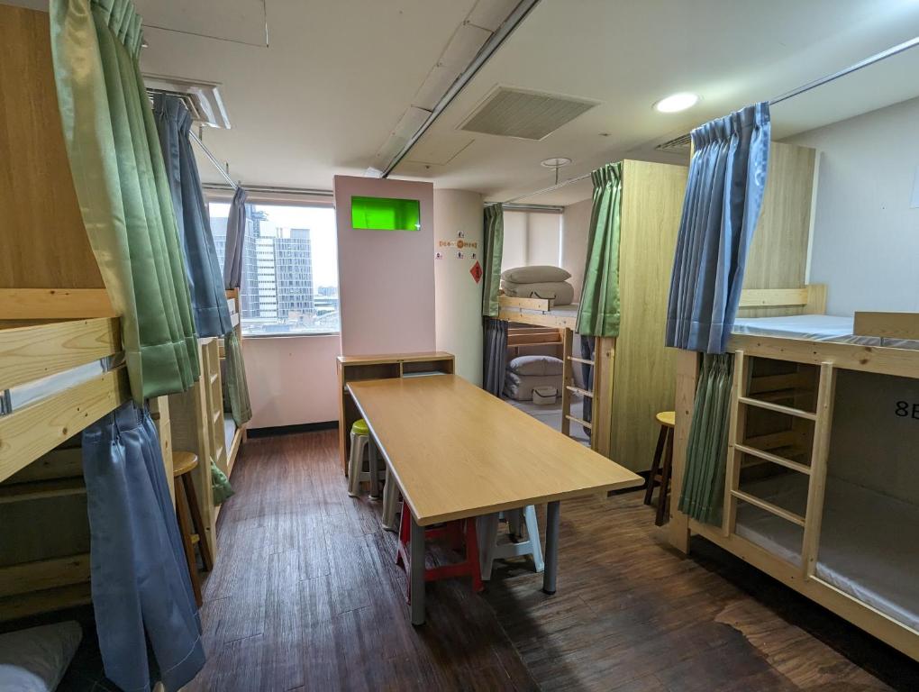 a room with a table and a desk in it at Hey Bear Capsule Hotel in Taipei
