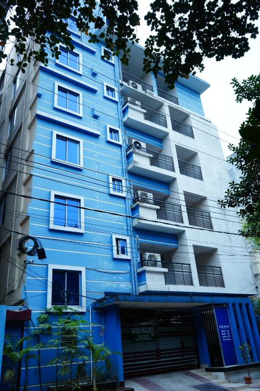 a blue apartment building with a garage at Garden Residents Uttara - Lake View in Dhaka