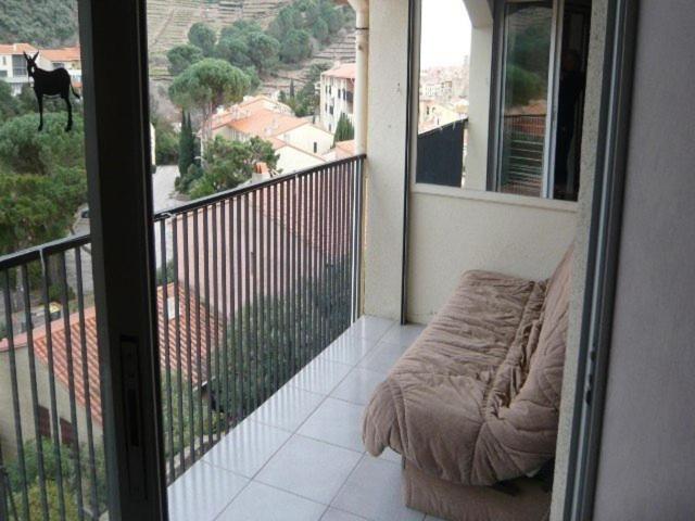 a balcony with a couch and a view of a city at 4VSE-LAM55 Appartement avec vue dégagée Collioure proche plage in Collioure