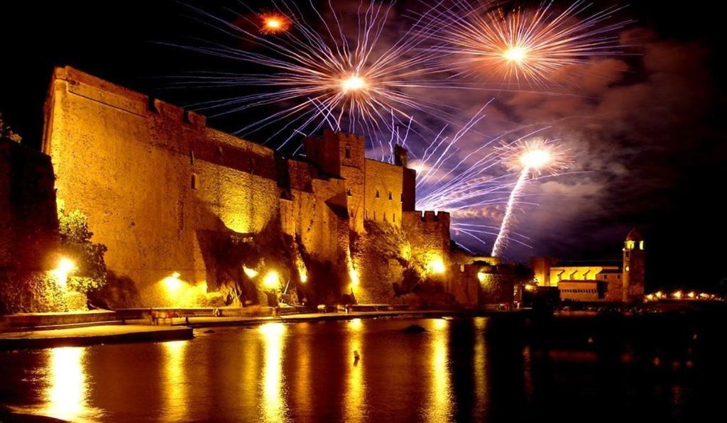 a castle with fireworks exploding in the sky over a street at 4VSE-LAM55 Appartement avec vue dégagée Collioure proche plage in Collioure