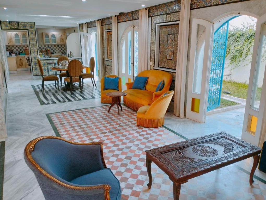 un soggiorno con sedie e tavolo di Dar Soltana a Sidi Daoud