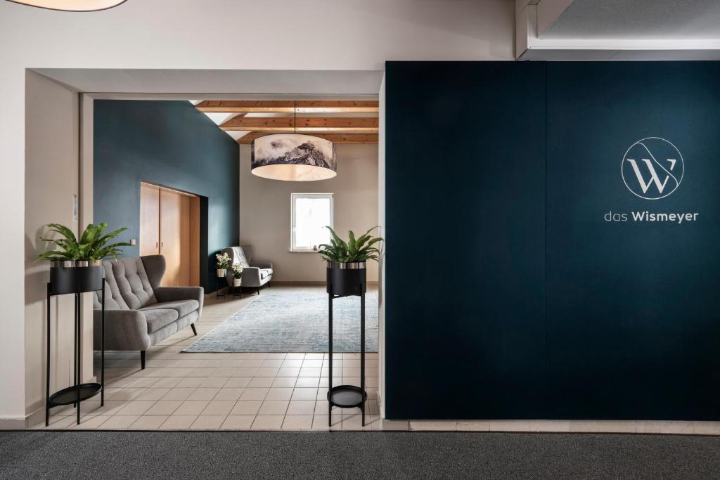 eine Lobby eines Büros mit blauer Wand in der Unterkunft Das Wismeyer in Obertauern