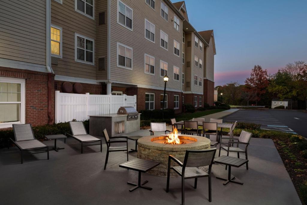 a patio with chairs and a fire pit in front of a building at Residence Inn Neptune at Gateway Center in Neptune City