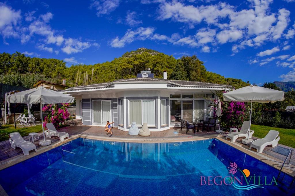 a swimming pool in front of a house at BegonVilla Fethiye-Göcek in Muğla