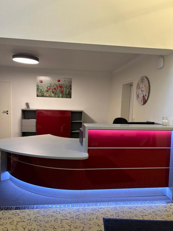 una sala de espera con un mostrador rojo y blanco en Waldgasthof Im Schwall en Nastätten