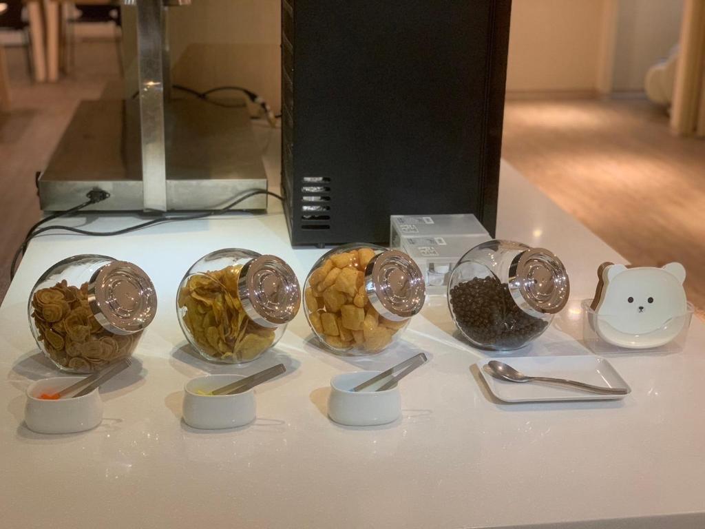 a table with four bowls of food and spoons at Yomi Hotel - ShuangLian MRT in Taipei