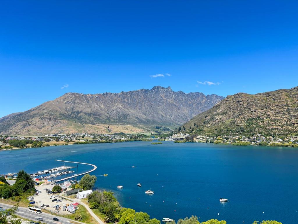 uma vista para um lago com montanhas ao fundo em Stunning Lakeview Holiday House Queenstown em Frankton