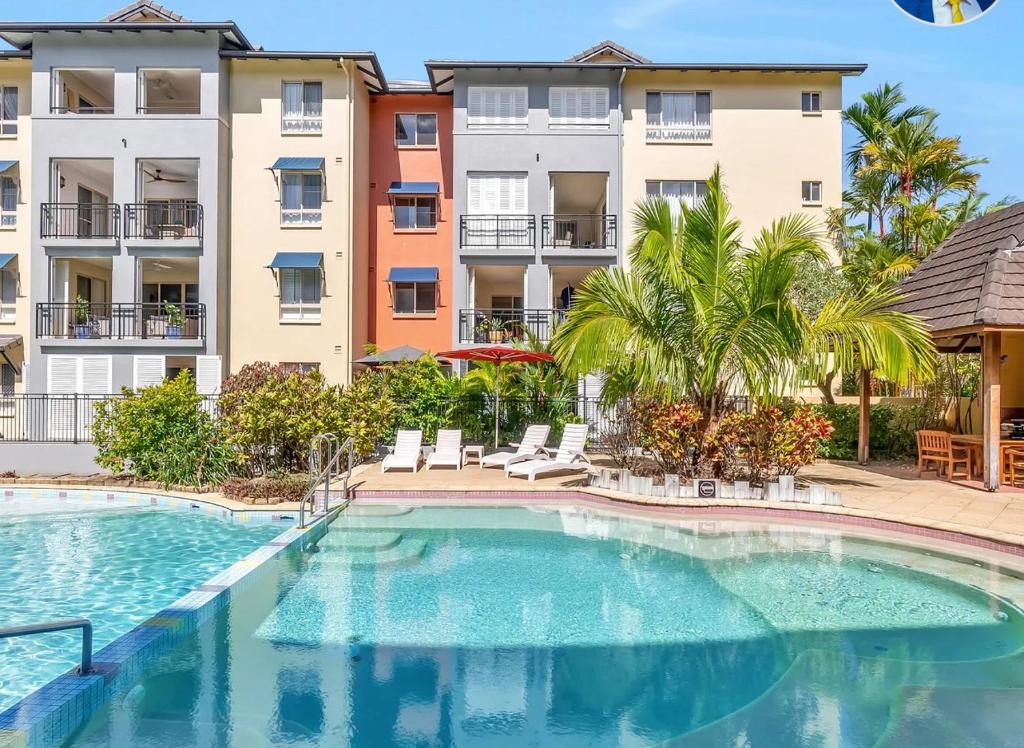 a swimming pool in front of some apartment buildings at Luxury tropical 2bedroom apartment in resort 4 swimming pools in Cairns North
