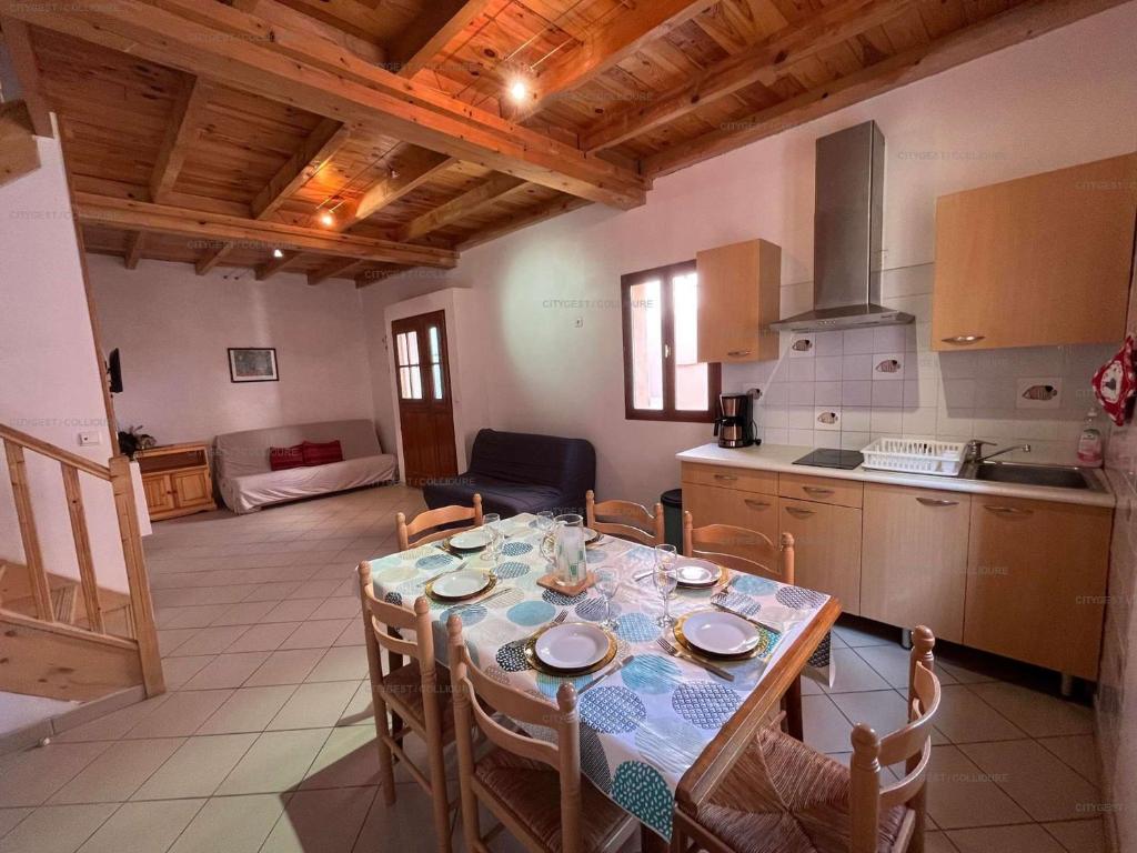 cocina y comedor con mesa y sillas en 6CONV20 charmante maison de village au cœur du faubourg en Collioure