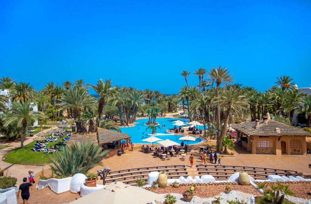 een luchtzicht op een resort met een zwembad en palmbomen bij Odyssee Resort Thalasso & SPA in Zarzis
