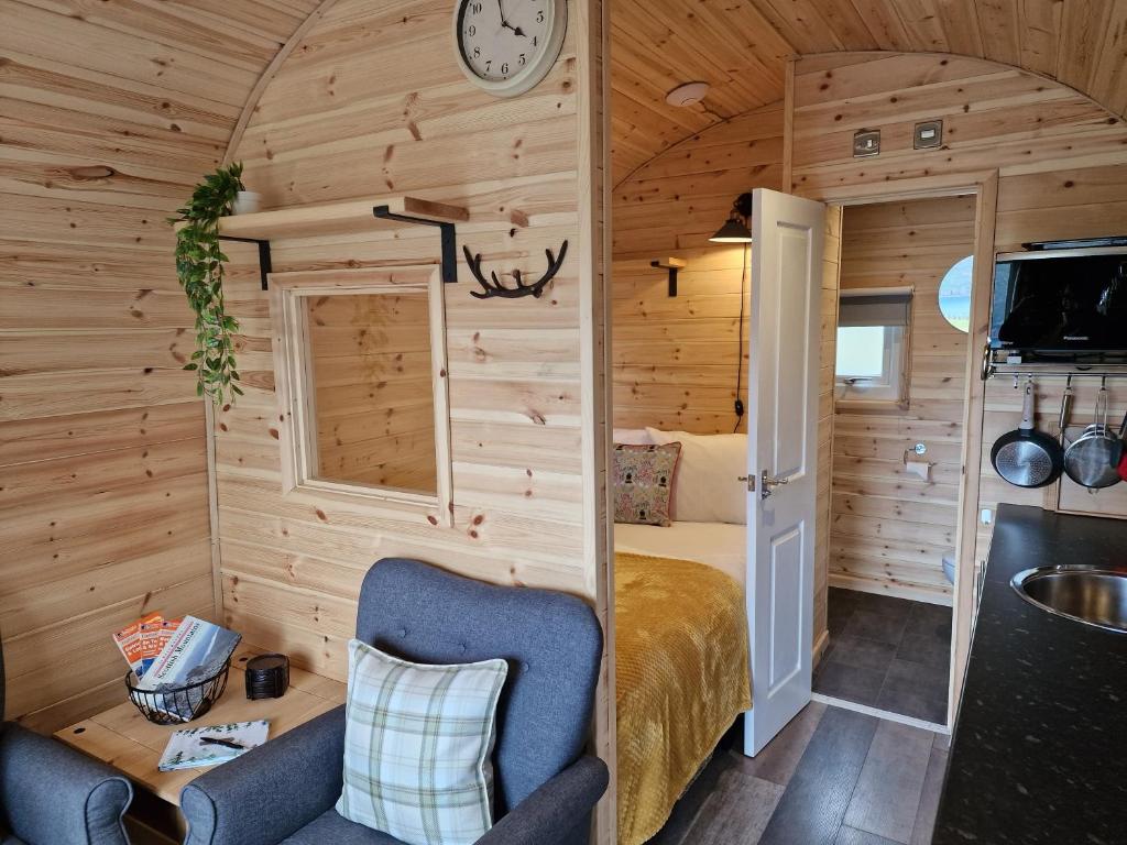Gorse Gorgeous Glamping Hideaway في Dundonnell: غرفة نوم في منزل صغير مع سرير
