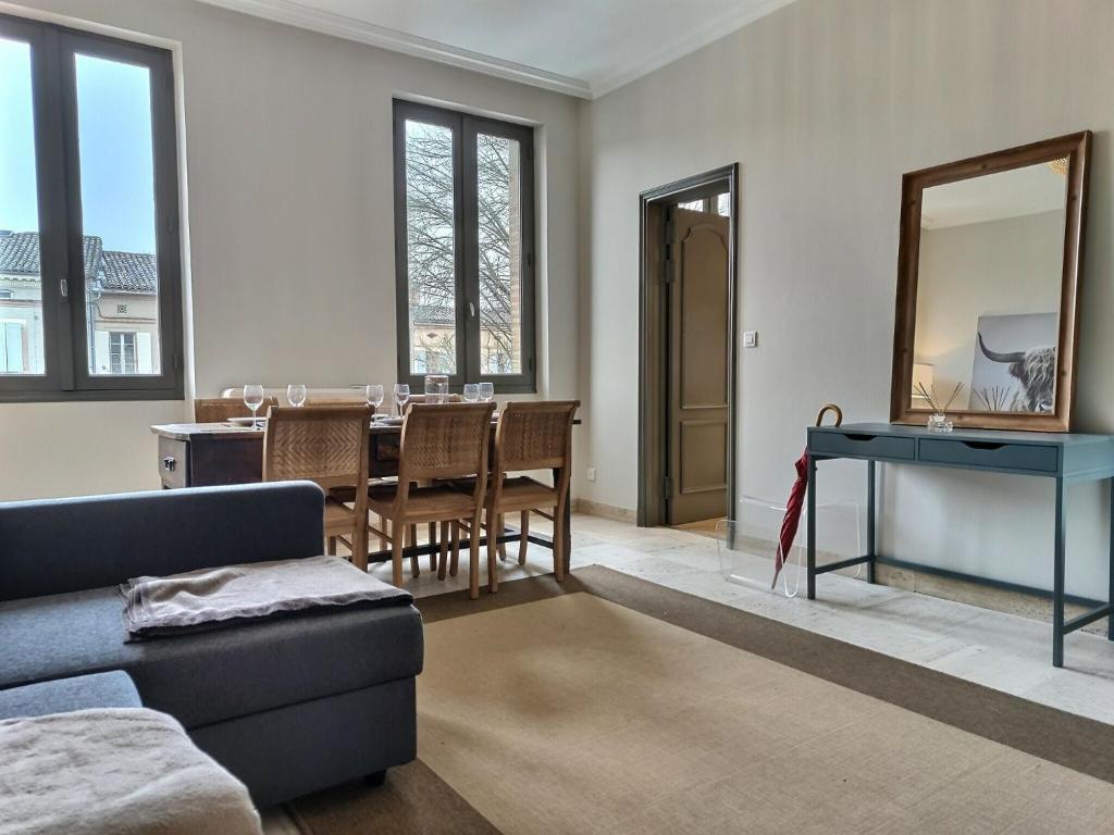 a living room with a couch and a table at Le Coté Cour - Fibre - Clim - Centre-ville in Albi
