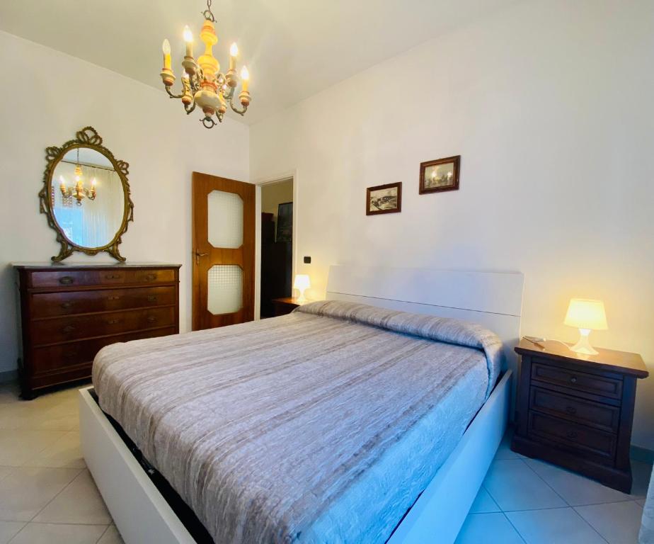 a bedroom with a bed and a mirror and a dresser at Hostdomus - La casina di Monica in Loano