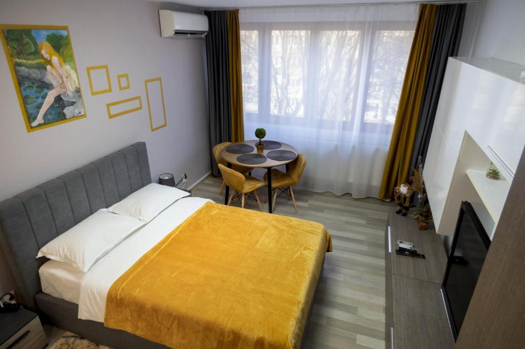 a hotel room with a bed and a table at Casa Rusu -Victoria-Self check in-24h in Reşiţa