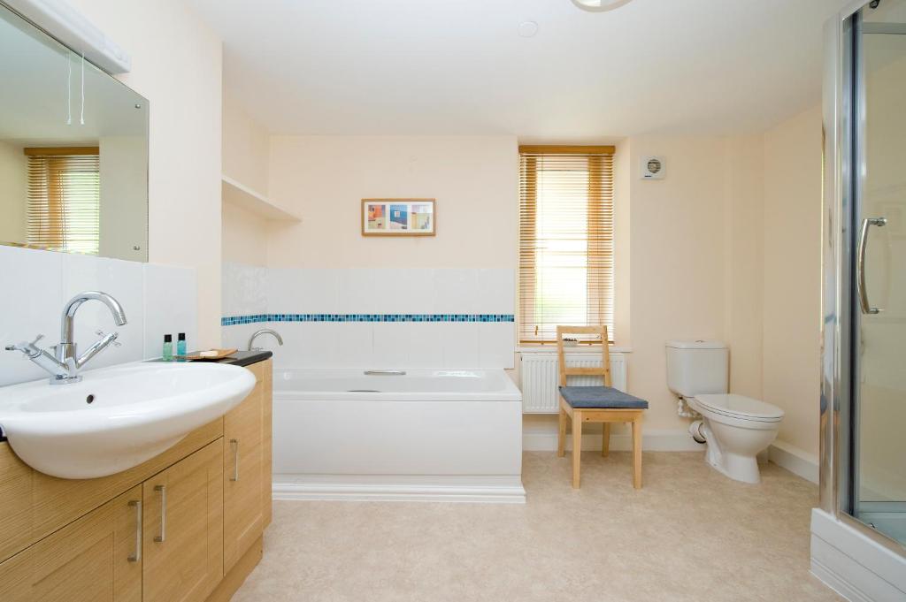 a bathroom with a sink and a tub and a toilet at Fron Haul in Aberdyfi