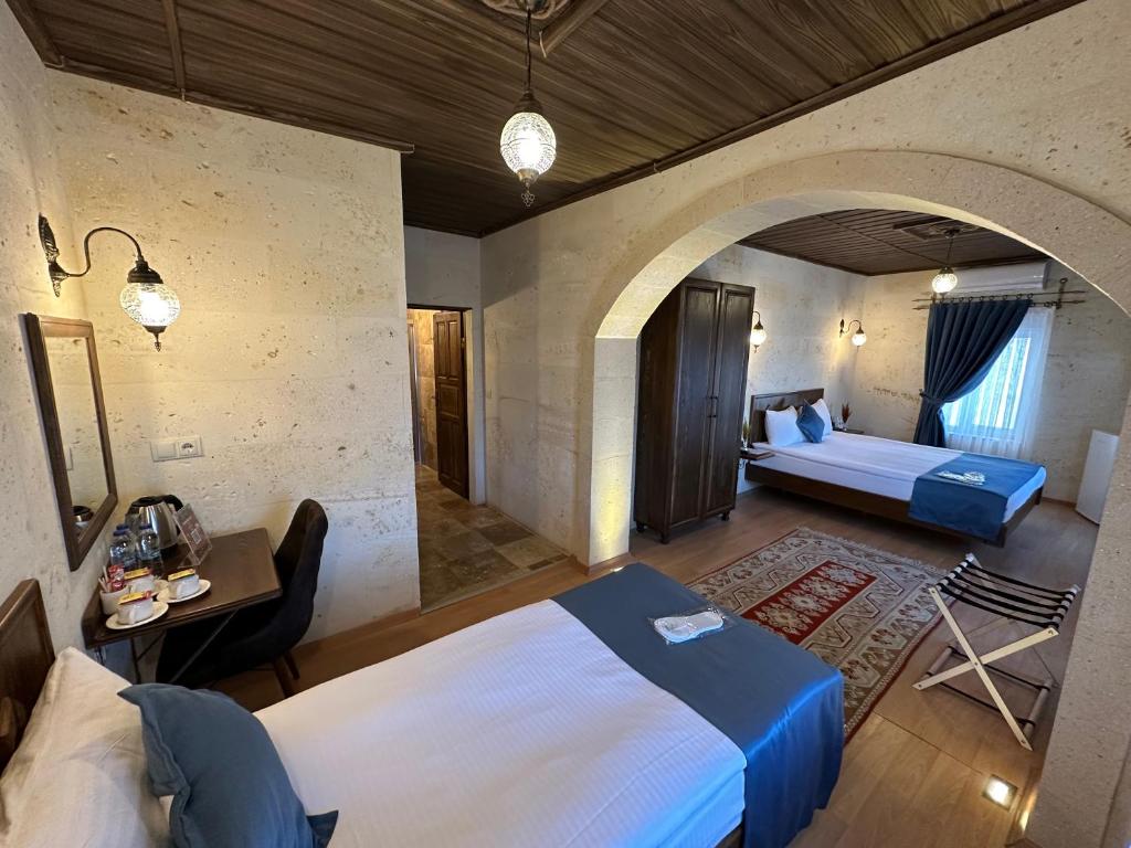 a bedroom with a bed and a room with a couch at Virtus Cappadocia Hotel Göreme in Goreme