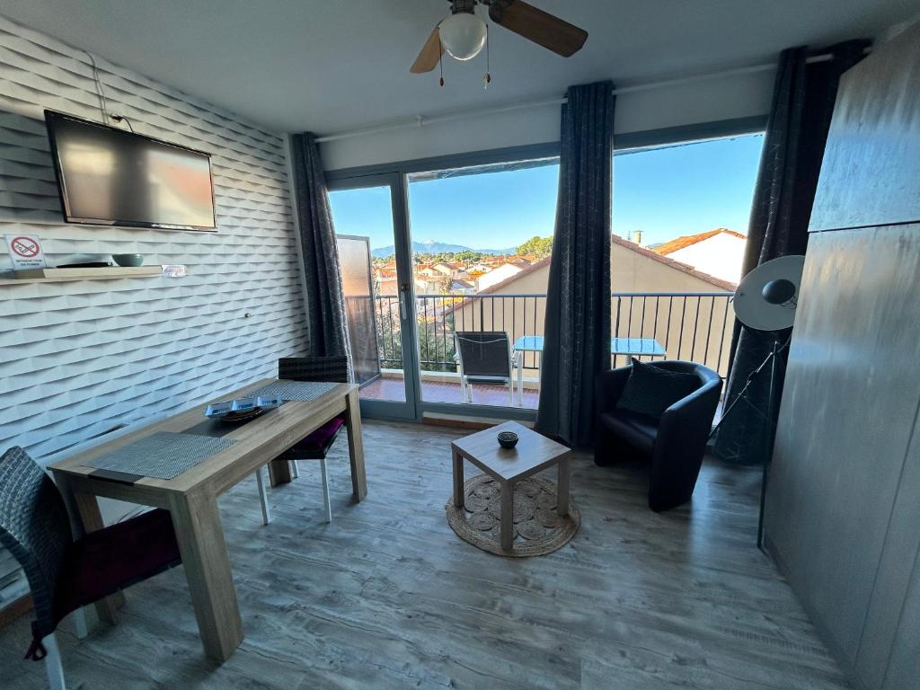 un salon avec une table et un canapé dans l'établissement Charmant studio 20 m de la plage, à Canet