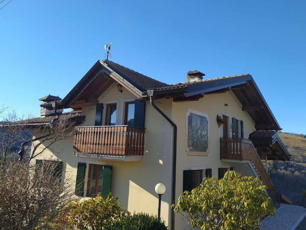 une maison blanche avec un balcon et des arbres dans l'établissement Villetta di montagna, à Foza