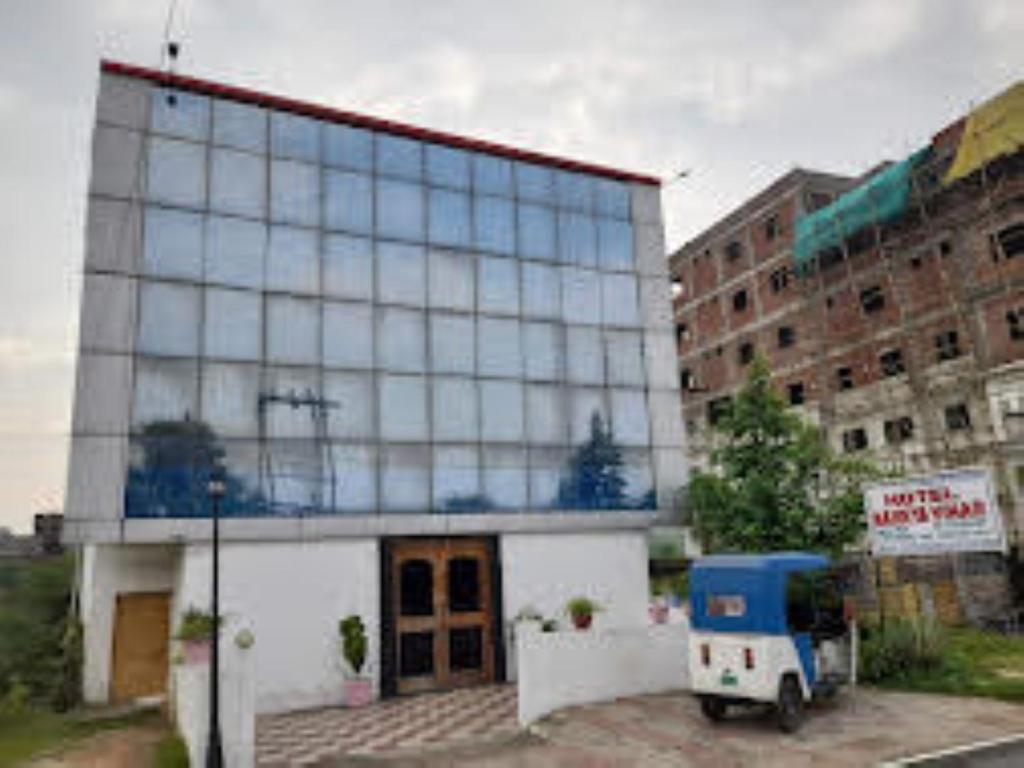 a building with a blue truck parked in front of it at Hotel Maurya Vihar Bodhgaya in Bodh Gaya