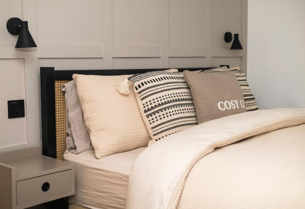 ein Schlafzimmer mit einem Bett mit Kissen darauf in der Unterkunft The Nook Cottage, Parkgate, Wirral in Parkgate
