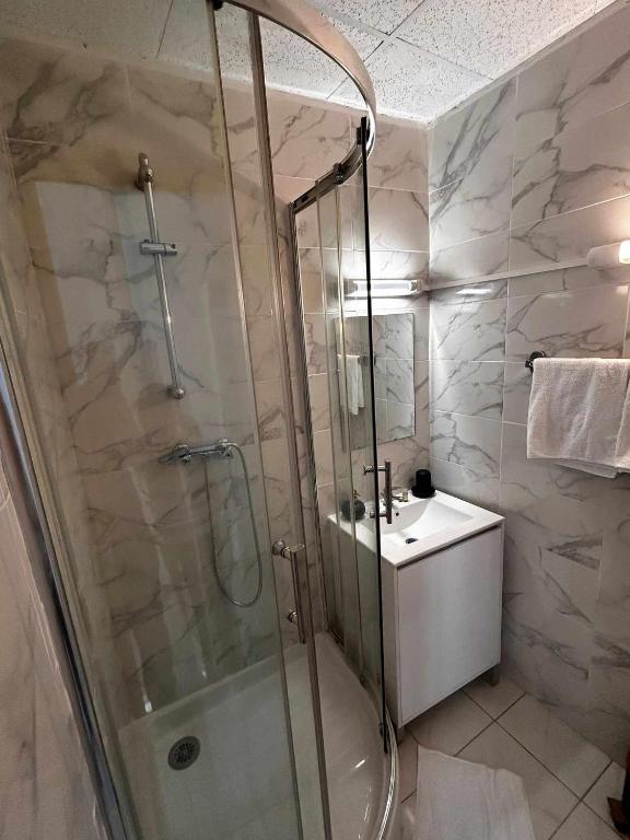 a bathroom with a shower and a sink at Hôtel du Champs de Mars in Béziers