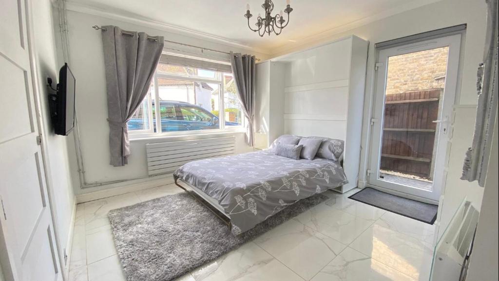 a bedroom with a bed and a window at Luxury studio apartment, Beckenham in Elmers End