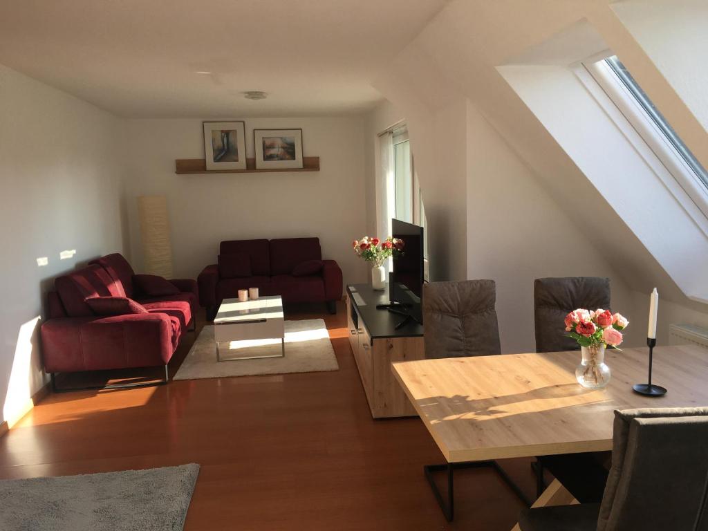 a living room with a red couch and a table at Sonnige Wohnung mit Balkon in Eppingen