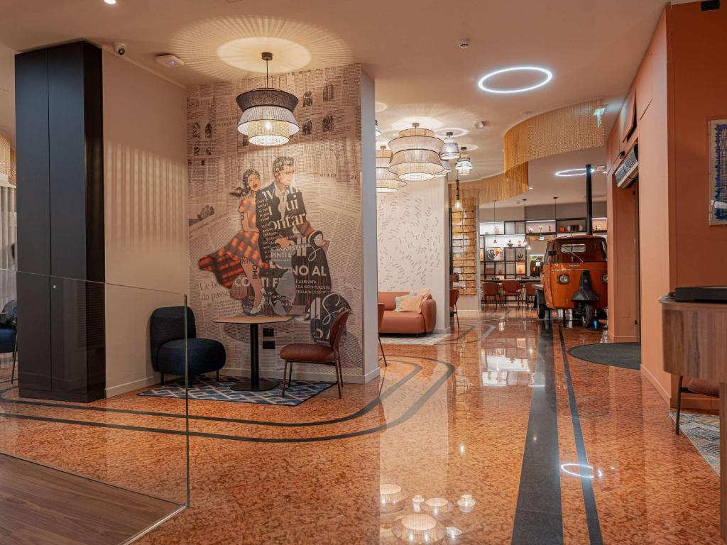 um lobby com um quadro na parede e uma mesa em Mercure Bologna Centro em Bolonha