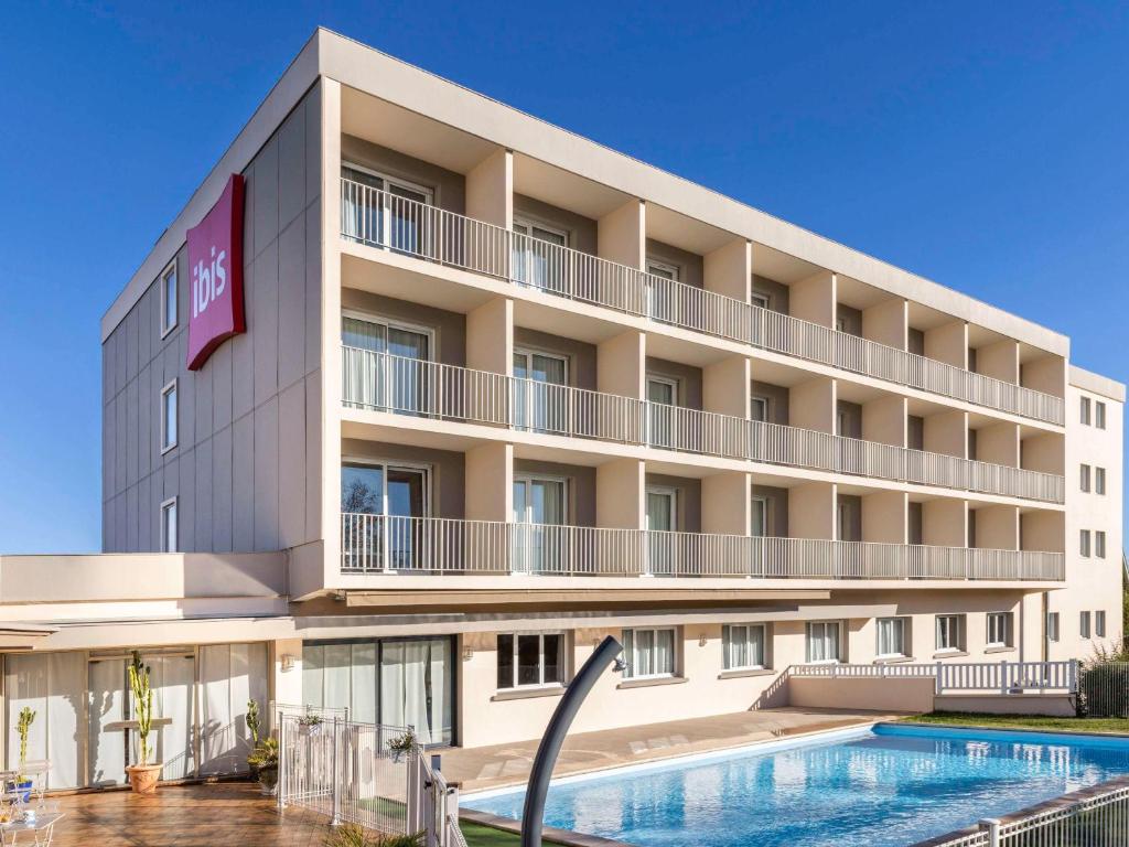 an image of a hotel with a swimming pool at ibis Tarbes Odos in Odos